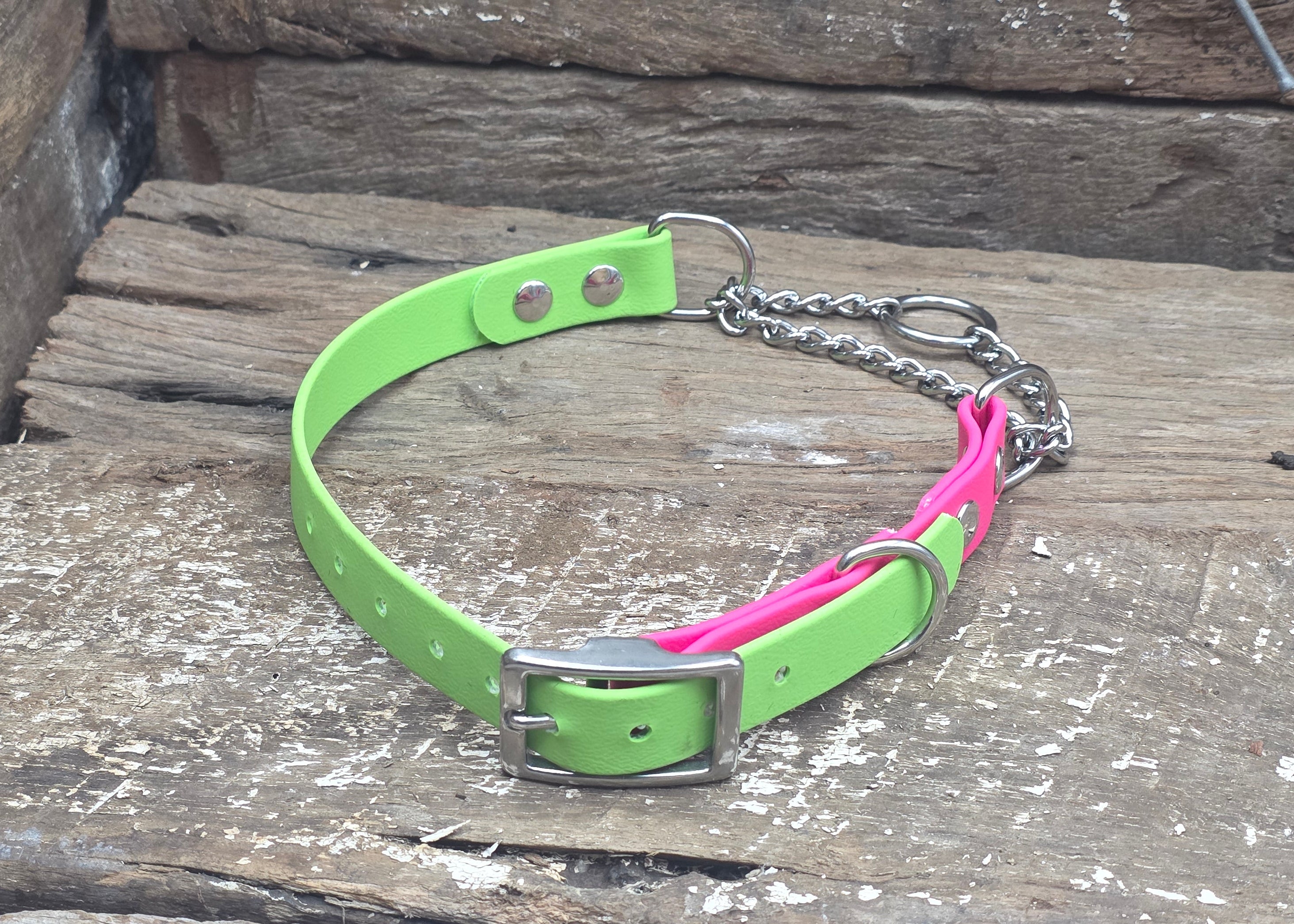 Neon green and pink dog collar with chain on a wooden surface