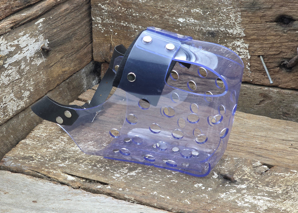 A translucent purple plastic guard with a dark blue strap and silver metal rivets, resting on a weathered wooden surface.